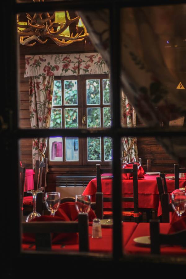 El salón con manteles rojos visto desde la ventana